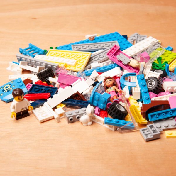 Een gripzakje gevuld met losse LEGO-blokjes in verschillende kleuren en vormen.